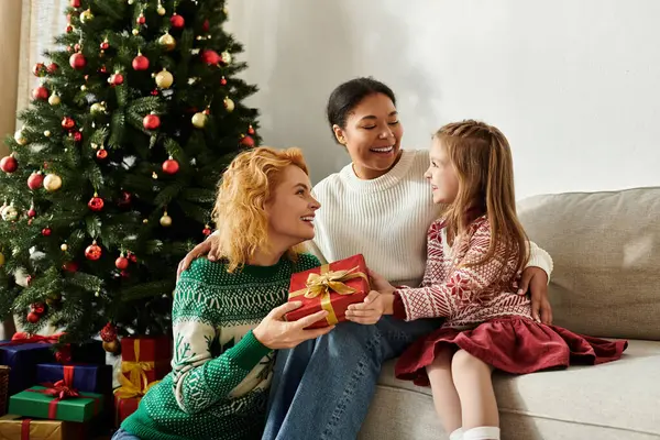 A loving couple shares a special moment with their daughter while celebrating together at home. — Stock Photo