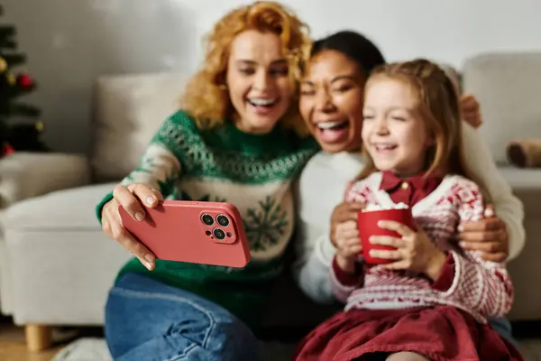 A joyful moment shared by a couple and their daughter while taking selfies. — Stock Photo
