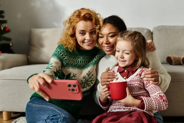 A loving couple smiles as they enjoy a playful moment with their daughter at home. — Stock Photo