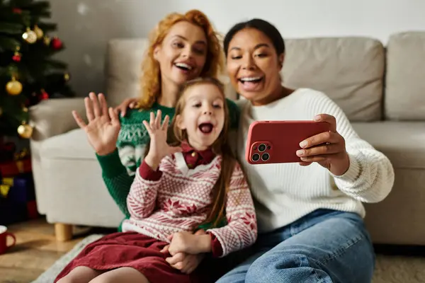 A happy couple and their daughter celebrate together at home, embracing warmth and joy. — Stock Photo