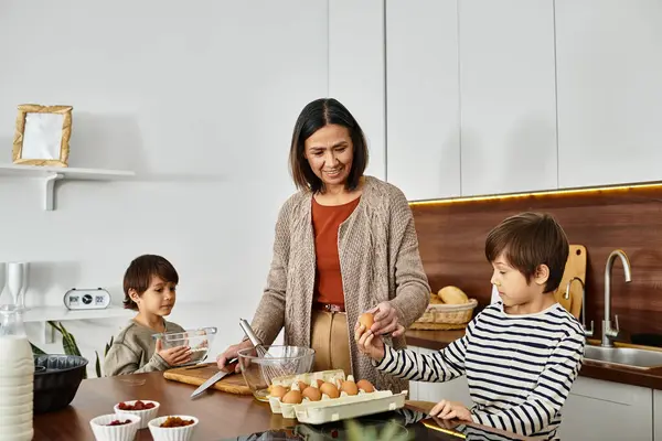 Eine fröhliche Großmutter backt in der Weihnachtszeit gern mit ihren Enkeln in einer warmen Küche. — Stockfoto