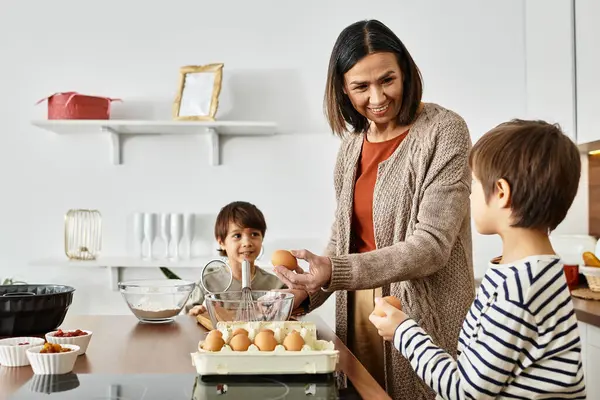 Eine fröhliche Großmutter teilt die Freude am Backen mit ihren Enkeln während sie sich auf Weihnachten vorbereiten. — Stockfoto