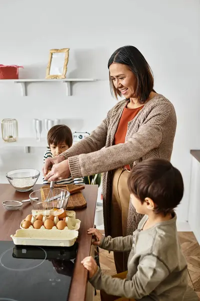 Eine fröhliche Großmutter kocht in der festlichen Winterzeit gern mit ihren Enkeln. — Stockfoto
