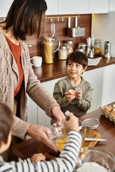 Eine fröhliche Großmutter teilt Urlaubsstimmung mit ihren Enkeln beim Backen in einer warmen, einladenden Küche. — Stockfoto