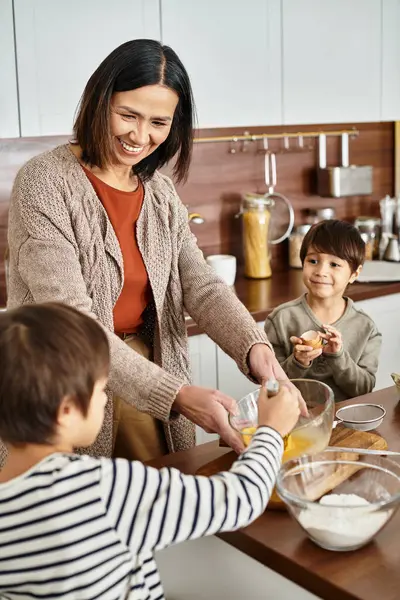 Eine Großmutter teilt einen köstlichen Kochmoment mit ihren Enkeln während der Winterferien. — Stockfoto