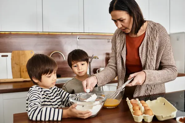 Eine glückliche Großmutter bringt ihren Enkeln bei, Leckereien für die bevorstehenden Weihnachtsfeiertage zu backen. — Stockfoto
