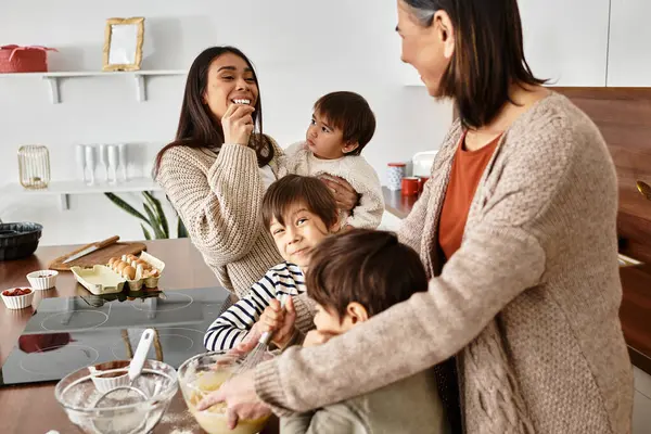 A cheerful family enjoys baking in their stylish kitchen, creating holiday treats with happy children. — Stock Photo