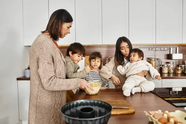 A cheerful family gathers in a modern kitchen, enjoying baking activities with their young children this winter. — Stock Photo