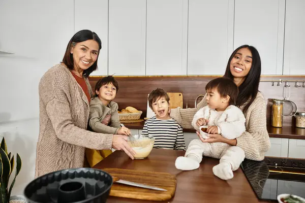 A joyful Asian family, including cute children, enjoys baking together in a cozy kitchen during the holidays. — Stock Photo
