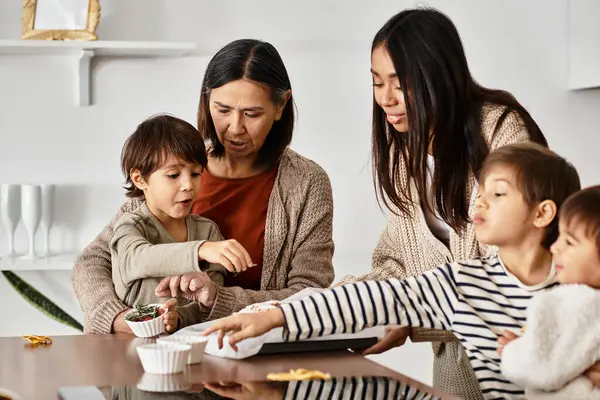 A cheerful Asian family gathers to bake festive treats, creating memories with laughter and joy during winter. — Stock Photo