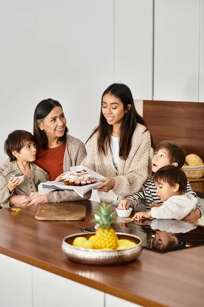 Una famiglia gioiosa condivide lo spirito natalizio, cuocendo deliziosi biscotti nella loro cucina moderna. — Foto stock