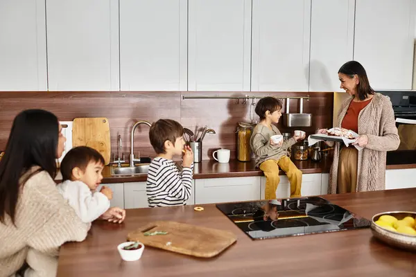 Una gioiosa famiglia asiatica condivide momenti di cottura e godendo di dolcetti festivi nella loro cucina elegante prima di Natale. — Foto stock