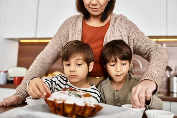 A cheerful family bonds over baking as children decorate holiday treats in a cozy modern kitchen. — Stock Photo