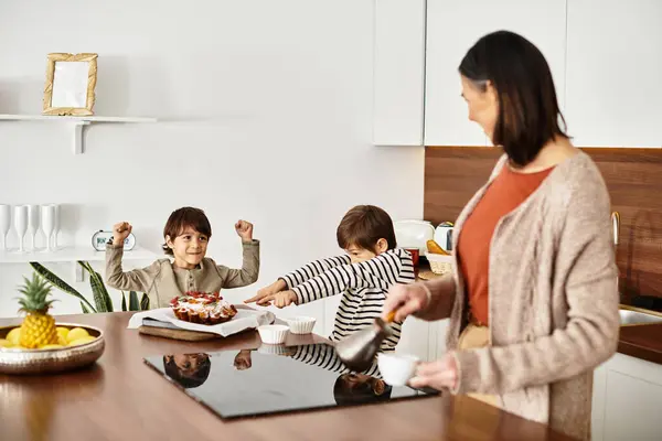 A happy family prepares festive treats in a contemporary kitchen, with children joyfully helping in the process. — Stock Photo