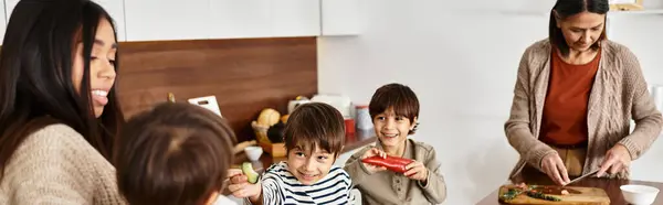 Una famiglia asiatica prepara felicemente deliziose prelibatezze natalizie nella loro cucina moderna con bambini allegri. — Foto stock