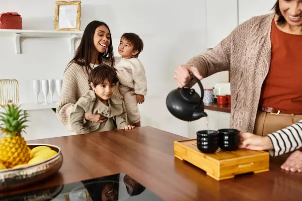 A happy family enjoys making tea together in a stylish kitchen, creating holiday memories with children. — Stock Photo