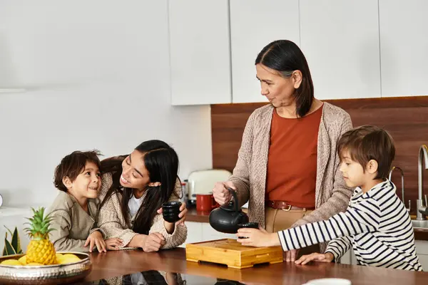 Una famiglia allegra si diverte a preparare il tè insieme nella loro cucina contemporanea. — Foto stock