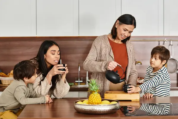 A cheerful family gathers in a stylish kitchen, making tea — Stock Photo