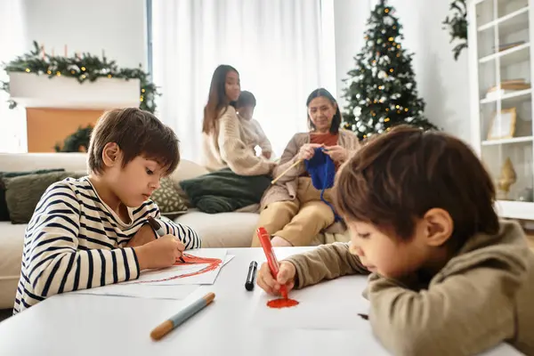 Una famiglia felice si riunisce in un salotto moderno, disegnando e godendo la reciproca compagnia vicino all'albero di Natale. — Foto stock