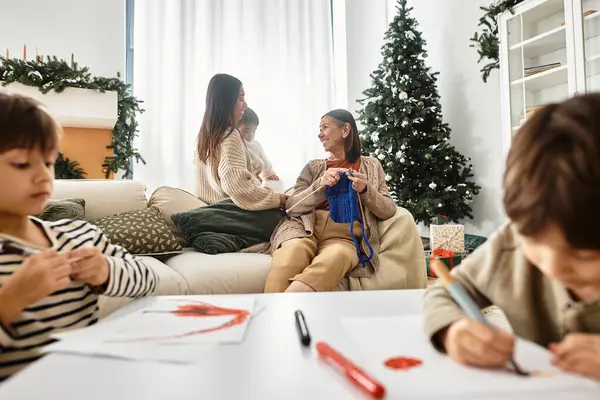 A happy Asian family enjoys their Christmas gathering, exchanging gifts and sharing joyful moments together. — Stock Photo