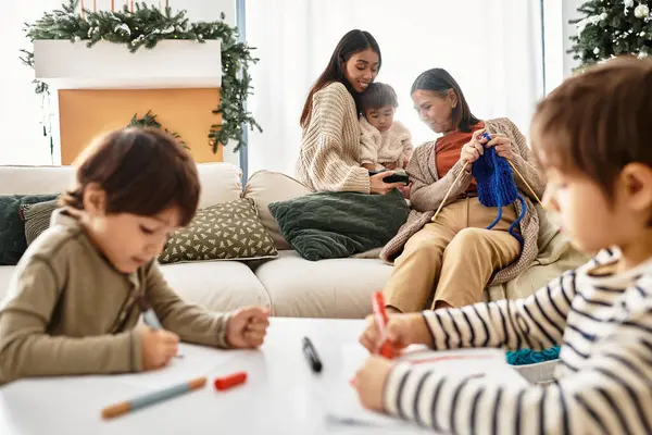 A cheerful family enjoys the holiday season by the Christmas tree, sharing joy and crafting together indoors. — Stock Photo