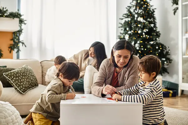 A joyful Asian family enjoys quality time together decorating near their Christmas tree, celebrating winter holidays. — Stock Photo