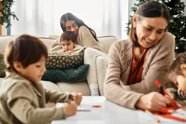 Una familia feliz disfruta del tiempo de calidad juntos cerca de un árbol de Navidad bellamente decorado, compartiendo risas. — Stock Photo