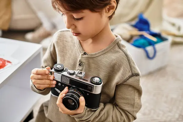 Bonito ásia menino ajustando digital câmera, celebrando o feriado temporada. — Fotografia de Stock