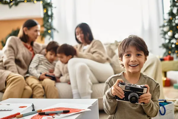 A happy family enjoys quality time together near a beautifully decorated Christmas tree, holding camera — Stock Photo