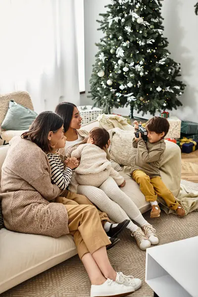 Eine glückliche Familie genießt Weihnachten am Baum und teilt Lächeln und Lachen in ihrem warmen Wohnzimmer. — Stockfoto