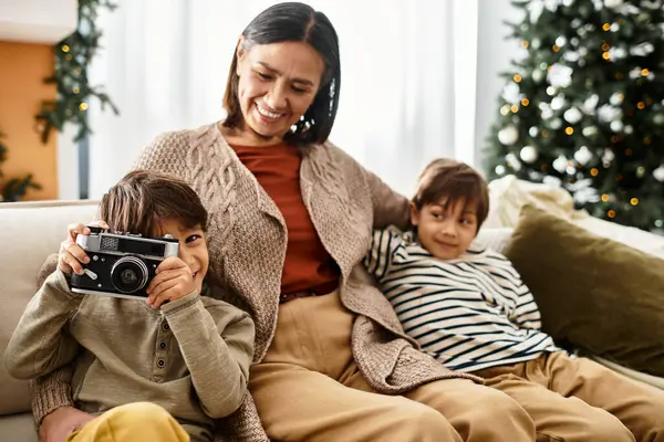 Una familia feliz disfruta del tiempo juntos cerca de un árbol de Navidad bellamente decorado, celebrando la alegría del invierno. — Stock Photo