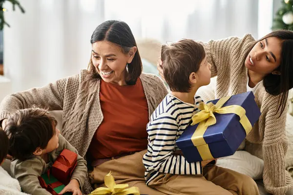 A happy family enjoys their time near a beautifully decorated room, sharing Christmas gifts and laughter. — Stock Photo