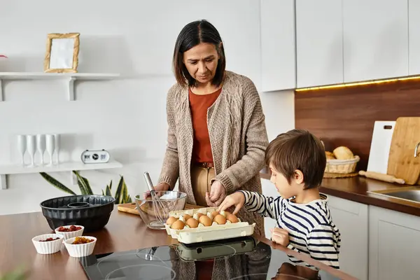 Eine glückliche Großmutter und ihr Enkel backen gemeinsam festliche Leckereien und teilen Lachen und Freude. — Stockfoto