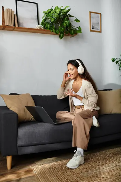 La donna sorride mentre partecipa a una vivace discussione virtuale dal suo elegante soggiorno. — Stock Photo