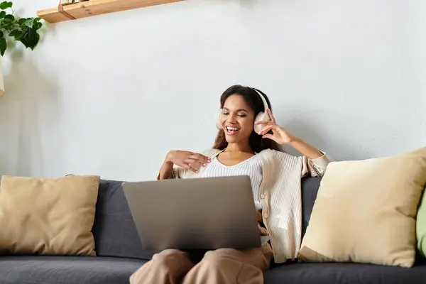 Eine Frau lächelt und unterhält sich lebhaft auf einer bequemen Couch. — Stockfoto