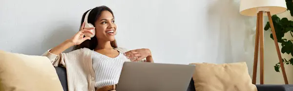 A cheerful woman in a cozy atmosphere chats happily while seated on her comfortable sofa. — Stock Photo