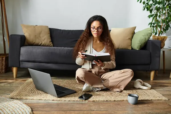 A focused woman enjoys her book while relaxing on a soft rug, surrounded by comfort and warmth. — Stock Photo