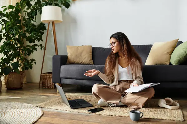 Una giovane donna in abbigliamento casual parla animatamente sul suo computer portatile mentre si rilassa in uno spazio sereno. — Foto stock