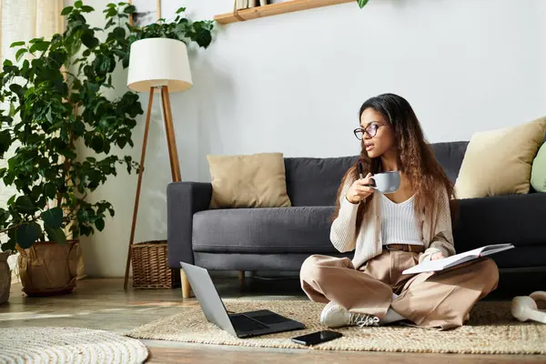 Uma mulher em traje casual se envolve em reflexão enquanto toma café em um aconchegante piso da sala de estar. — Fotografia de Stock