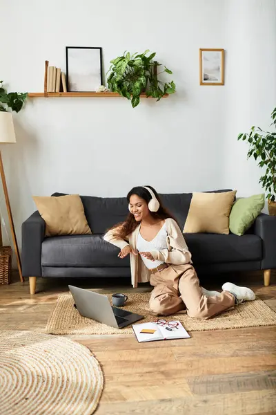A woman smiles while listening to music on her headphones in a stylish living space. — Stock Photo