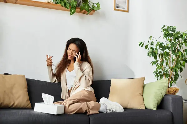 A woman sits on a cozy couch, deep in conversation, expressing her emotions and thoughts. — Stock Photo