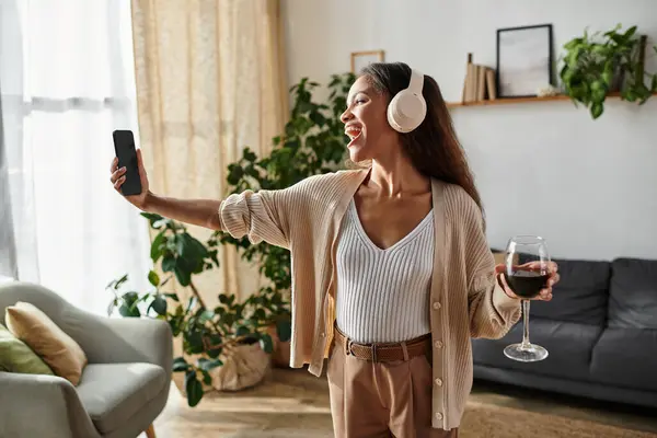 This woman expresses her happiness as she captures a fun moment with her drink in hand. — Stock Photo