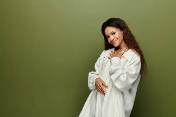 Uma mulher linda vestida com trajes suaves sorri calorosamente enquanto mostra seu olhar elegante. — Fotografia de Stock