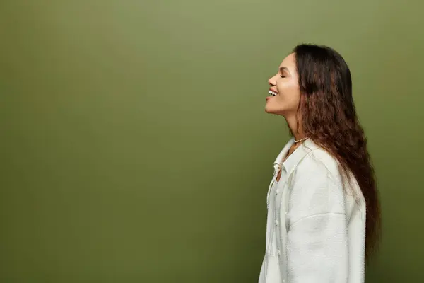 A cheerful woman stands gracefully, enjoying a moment of joy in a tranquil green setting. — Stock Photo