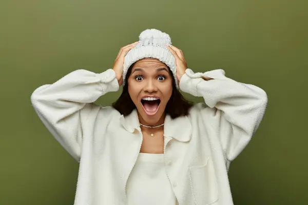 A woman joyfully raises her hands to her head, showcasing her surprise and delight. — Stock Photo