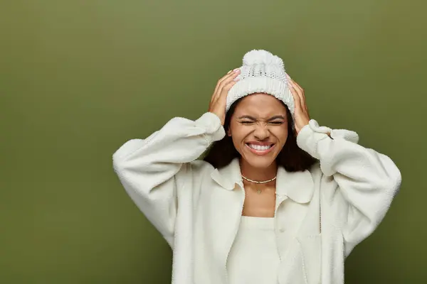 A cheerful woman smiles warmly while playfully holding her head, radiating happiness. — Stock Photo