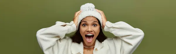 A cheerful woman with a bright smile enjoys the winter ambiance while wearing a cozy beanie. — Stock Photo