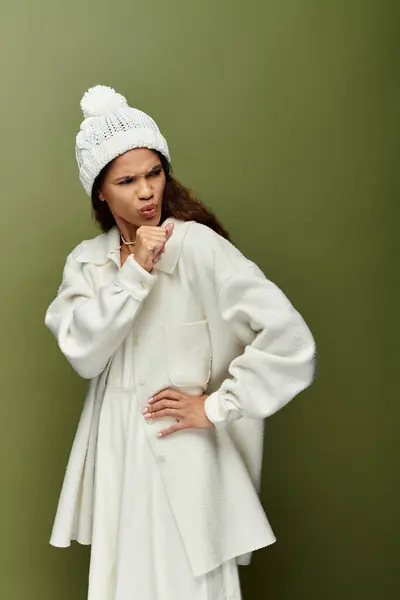 A confident woman playfully gestures with a charming expression while dressed in white. — Stock Photo