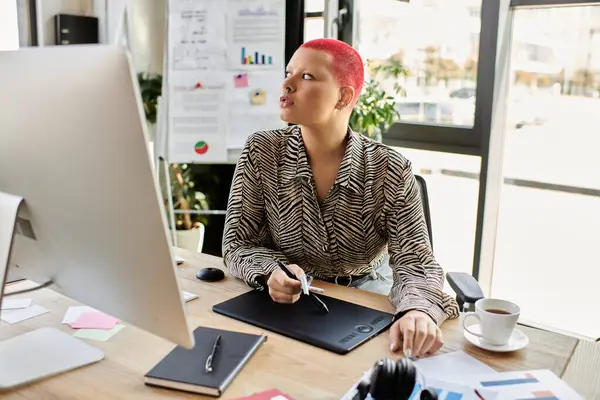 A stunning bald woman focuses intently on her digital art while enjoying her workspace. — Stock Photo