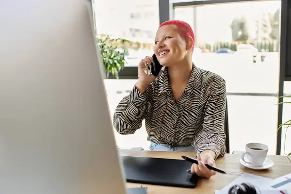A vibrant bald woman smiles while talking on her phone at a stylish workspace with greenery. — Stock Photo